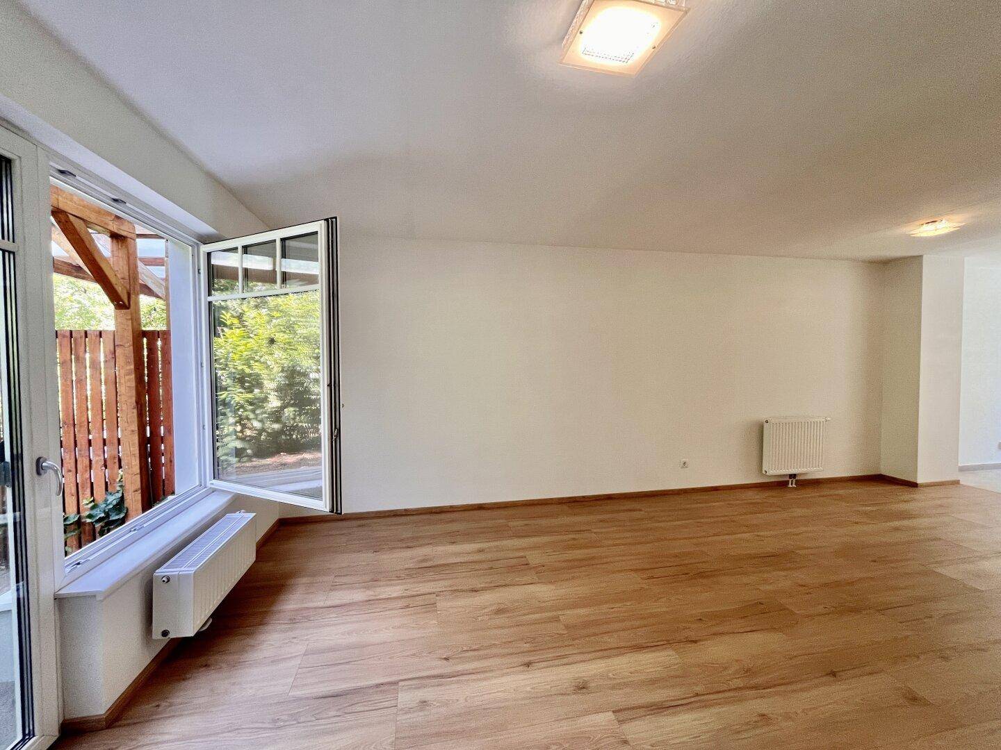 Geräumiges Wohnzimmer mit viel Tageslicht und direktem Zugang zur überdachten Terrasse.