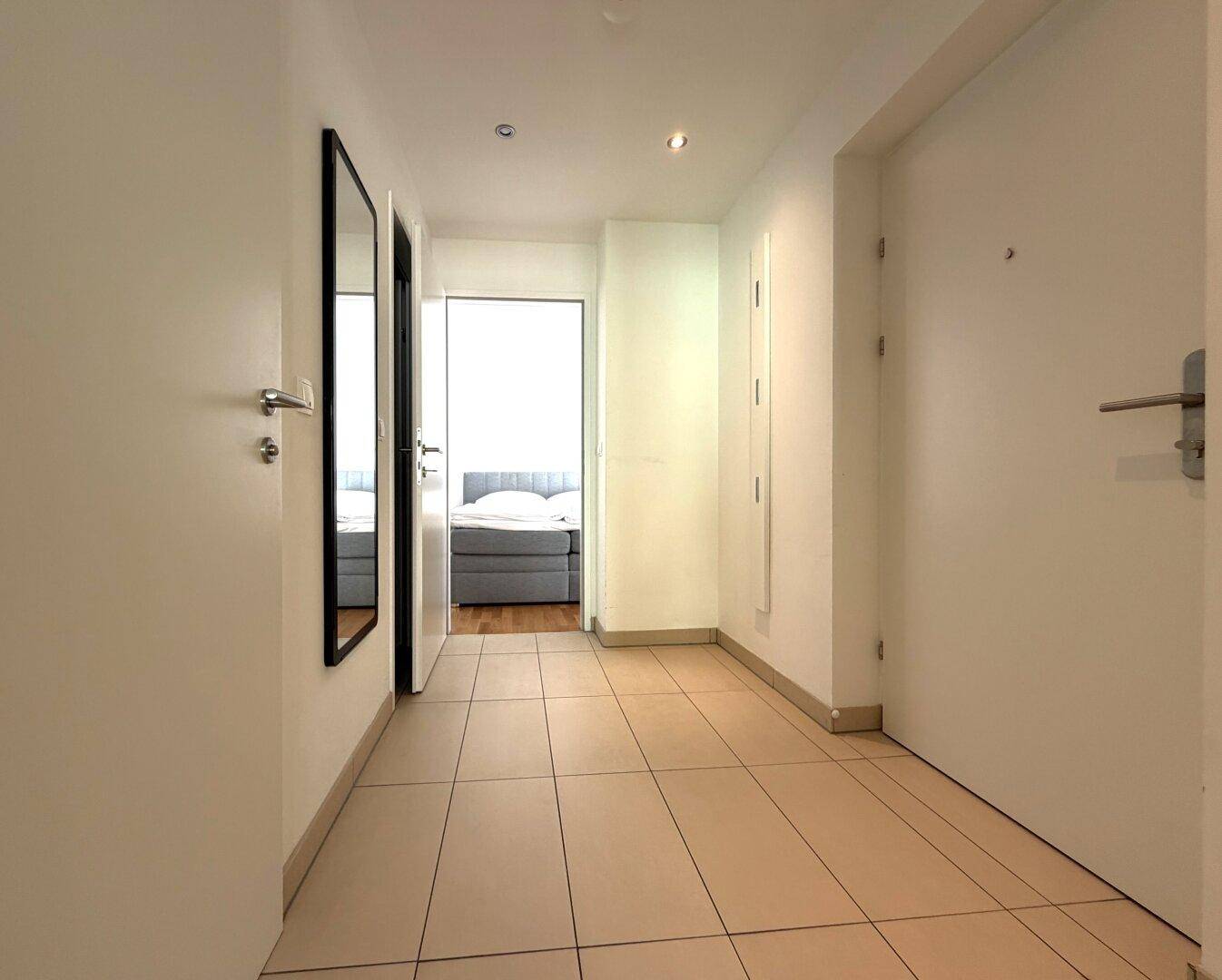 Geräumiger Flur mit Fliesenboden, der Zugang zu den verschiedenen Zimmern der Wohnung bietet.