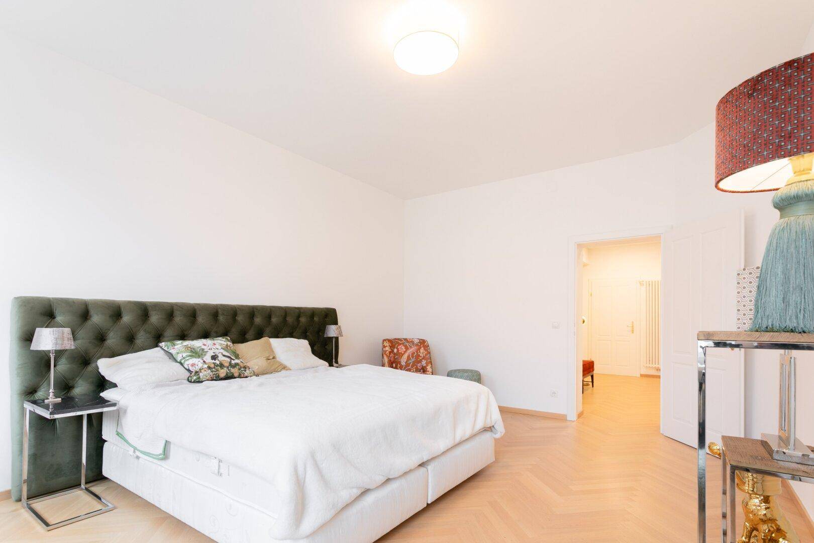Schlafzimmer mit stilvoller Einrichtung, hohen Decken und viel natürlichem Licht.