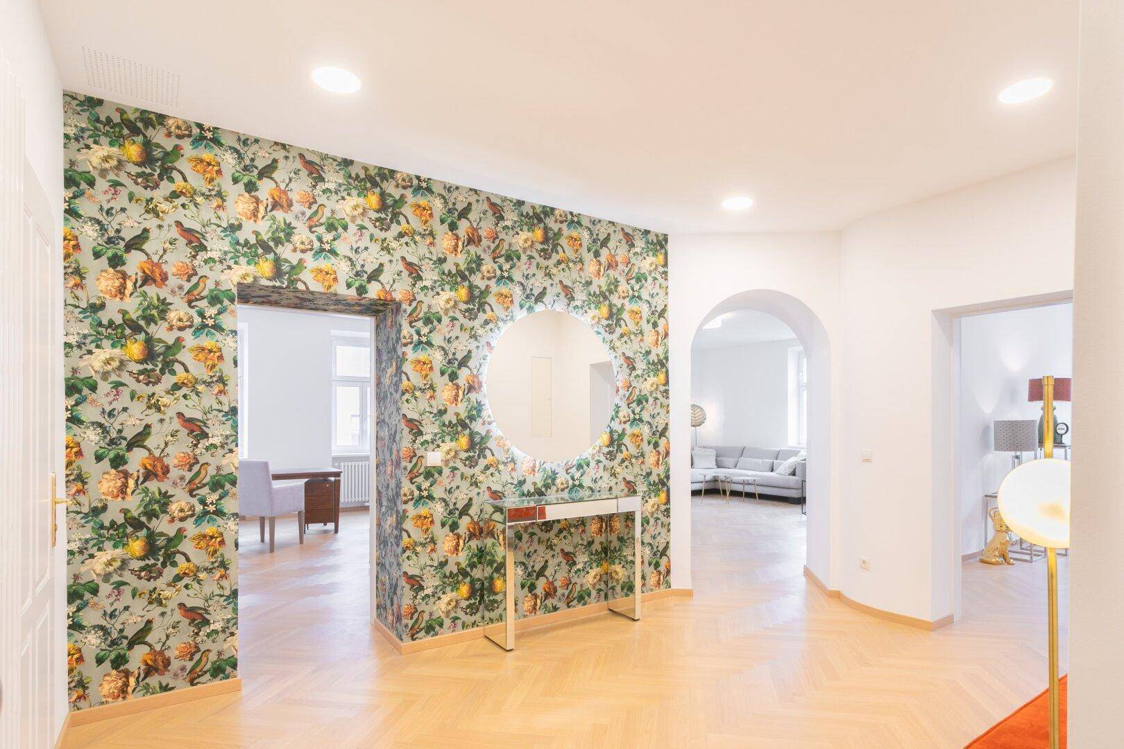 Geräumiger Flur mit dekorativer Tapete, der zu verschiedenen Räumen der Wohnung führt.