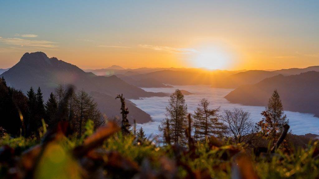 Malerischer Sonnenaufgang über den Bergen mit Nebelmeer in den Tälern.