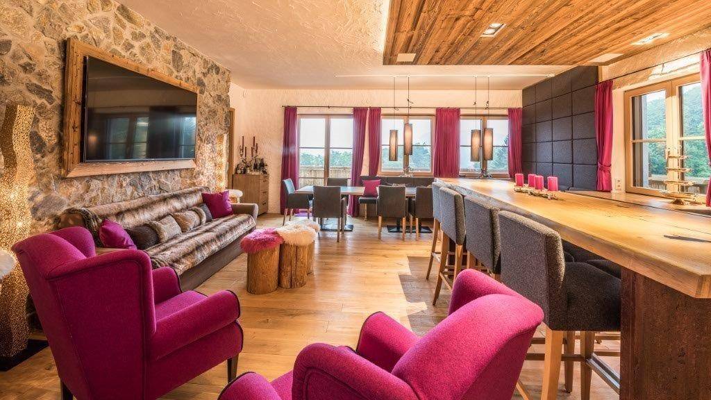 Geräumiger Wohn-Essbereich mit rustikalen Holzelementen, Steinwand und gemütlicher Atmosphäre.