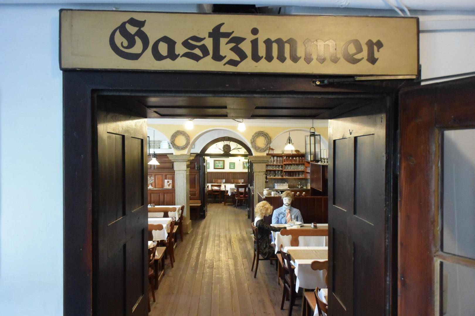 Eingangsbereich zu einem Gastzimmer mit Holzböden, traditionellen Möbeln und Blick in weitere Speiseräume.