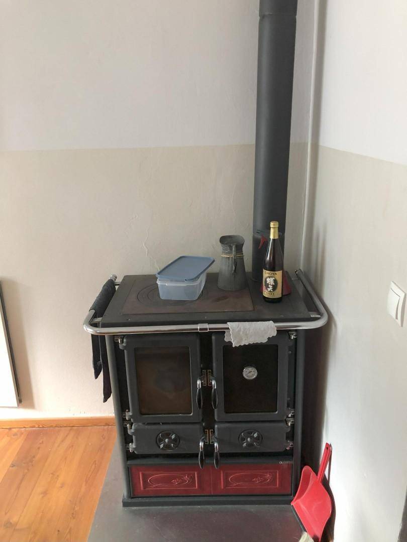 Detailansicht des traditionellen Holzofens in der Küche, der zum Kochen und Heizen dient.