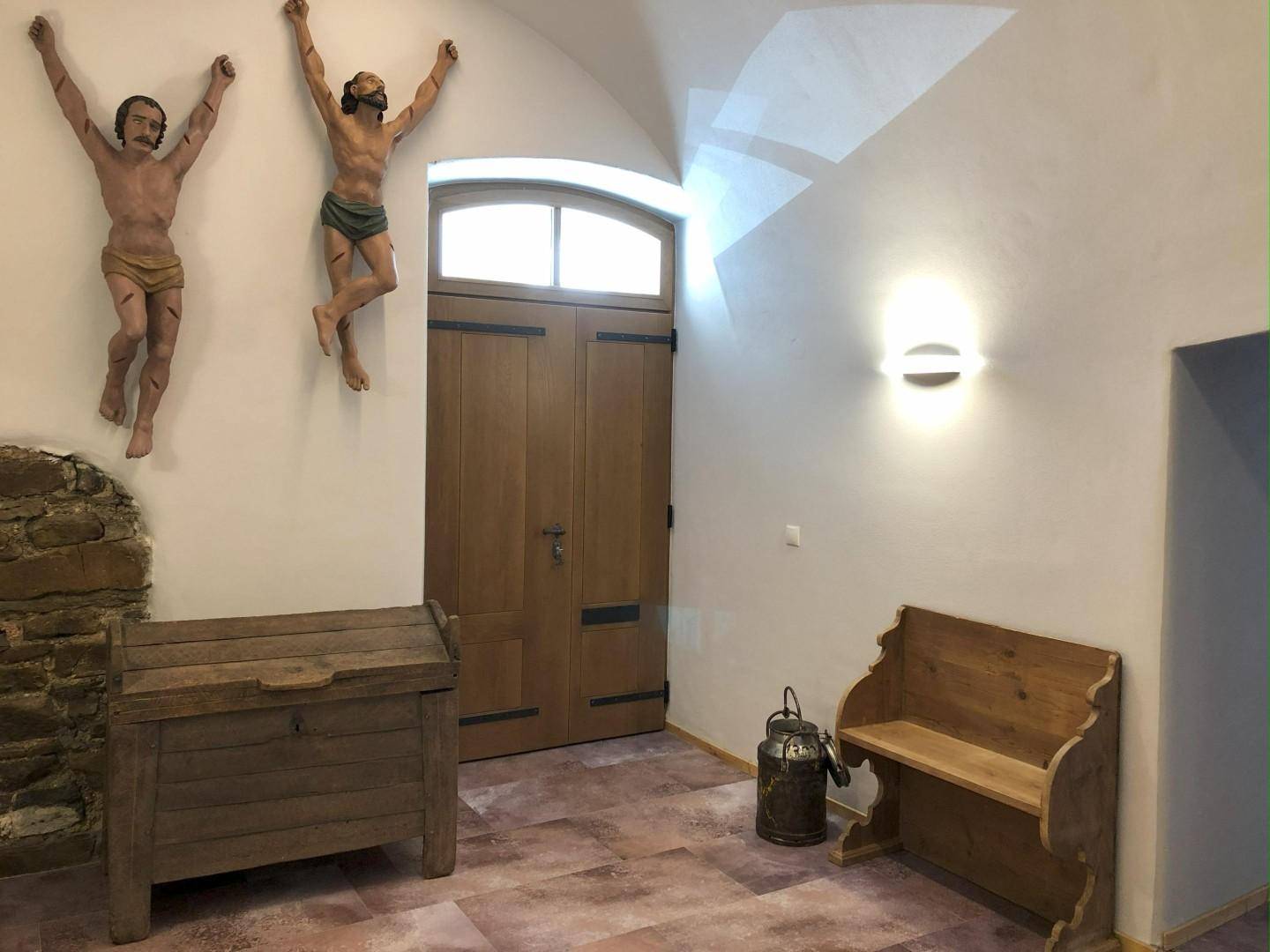 Eingangsbereich mit gewölbter Decke, Holztür und traditionellen Dekorationselementen.