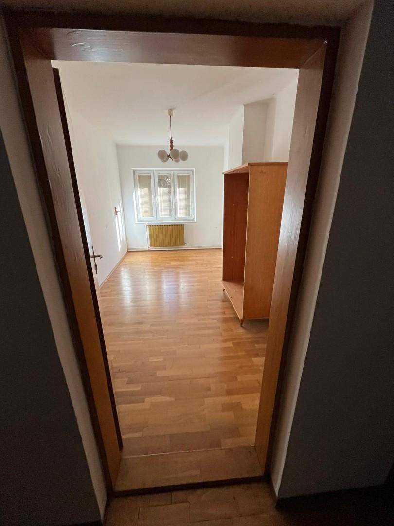 Helles Zimmer mit Holzdielenboden und großem Fenster, ideal als Schlafzimmer oder Büro.