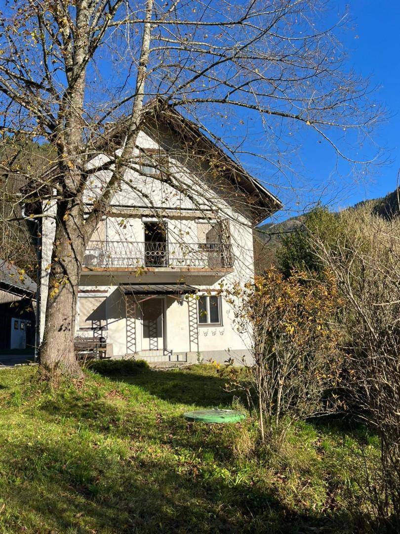 Älteres Haus mit Balkon und Blick auf die umliegende Berglandschaft im Herbst.
