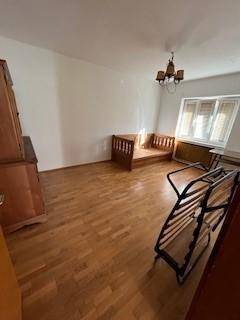 Schlafzimmer mit Holzdielenboden, Fenster und Platz für ein Bett, einfach und funktional.
