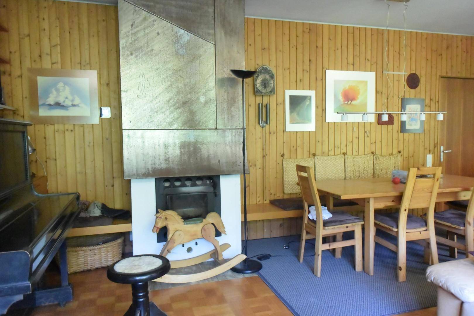 Detailansicht des Essbereichs mit Holztisch und Kamin, umgeben von warmen Holzwänden.
