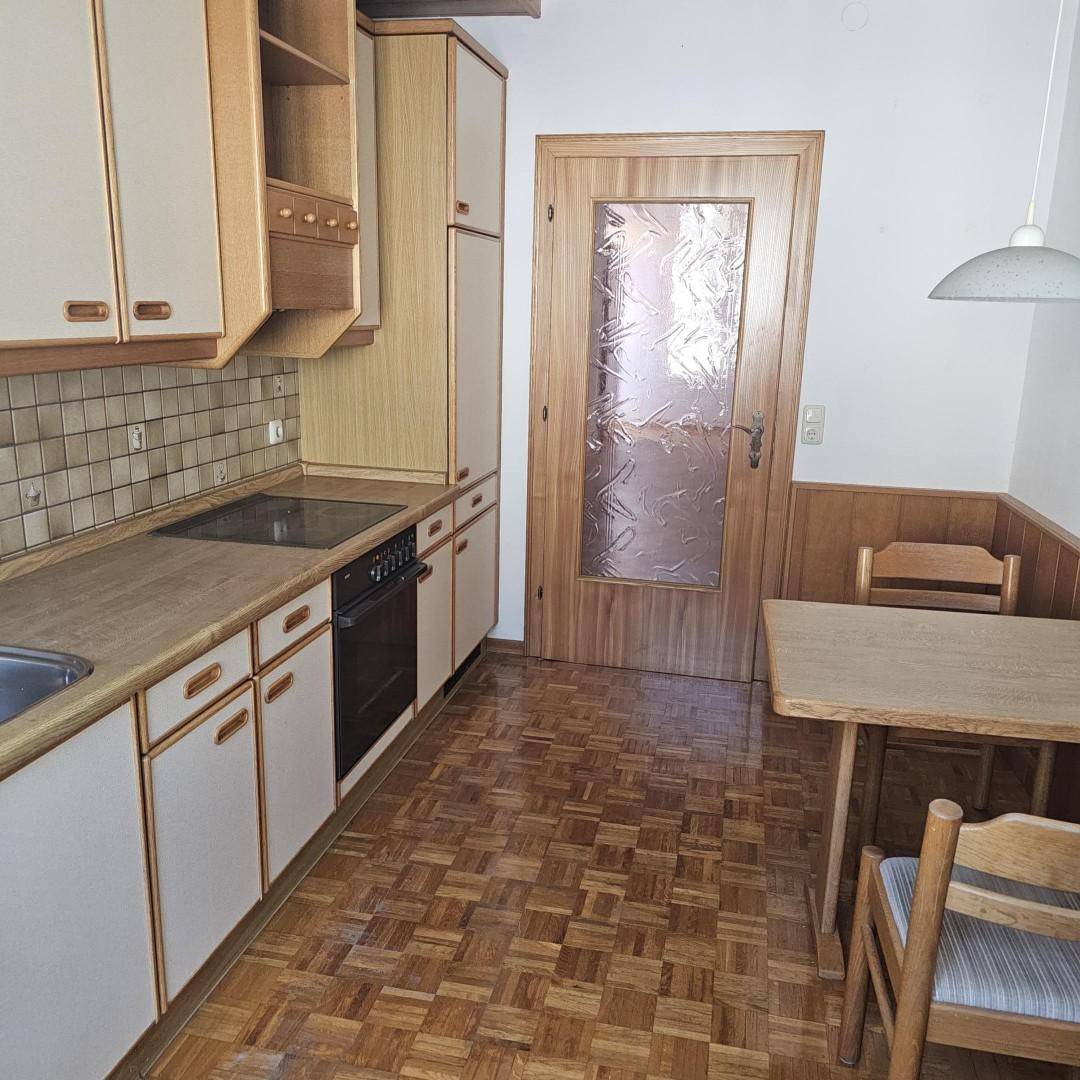Gemütliche Küche mit Essbereich, Holzmöbeln und Parkettboden.