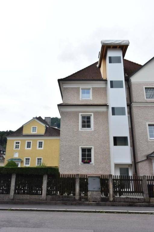 Wohnhaus mit einem nachträglich angebauten externen Aufzugsschacht für barrierefreien Zugang.