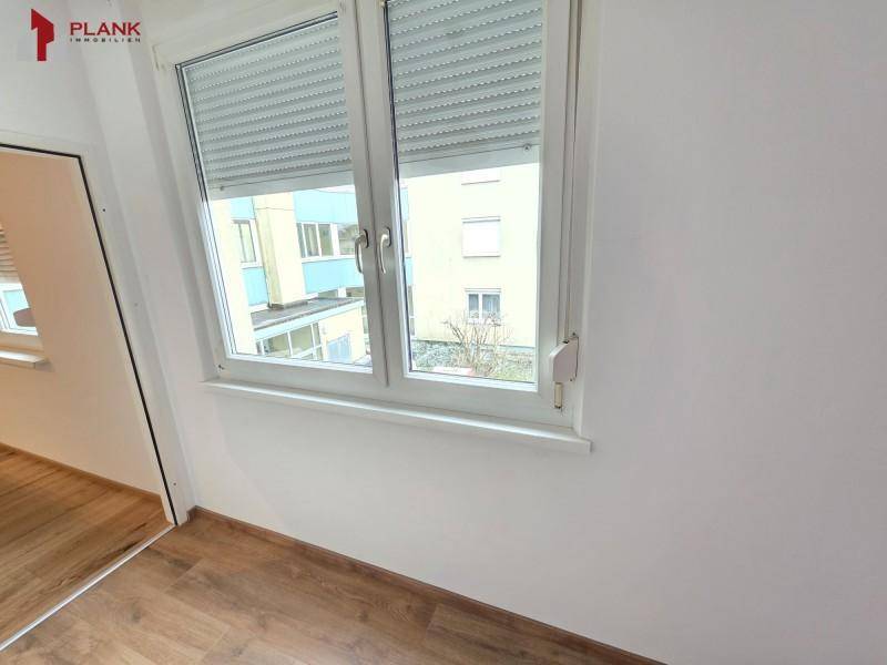 Fenster mit Rollläden und Blick auf die umliegenden Gebäude, sorgt für Privatsphäre.