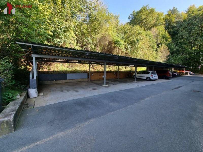 Überdachter Parkplatzbereich mit mehreren Stellplätzen für Fahrzeuge.