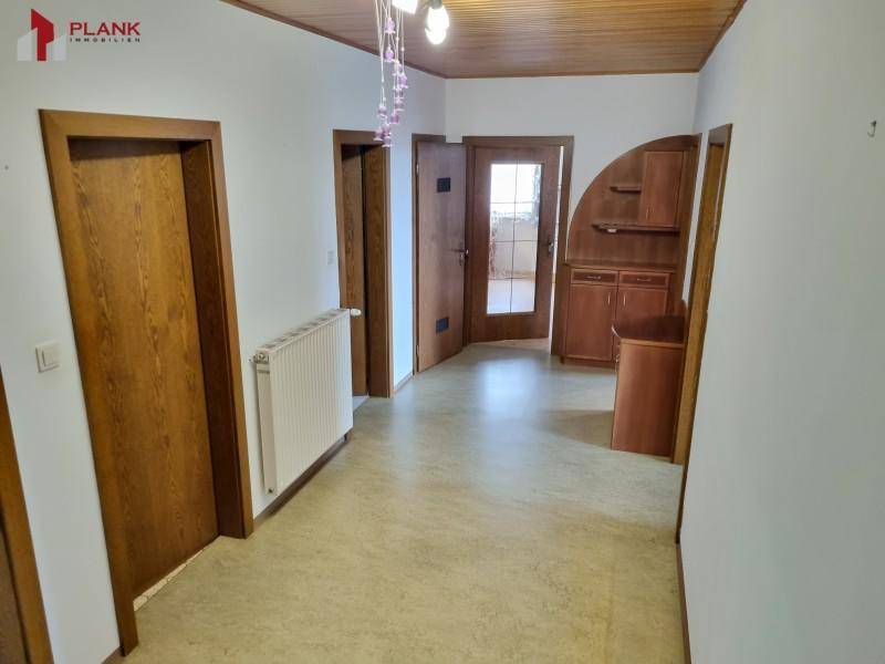 Heller Flur mit Holzdecken, mehreren Türen und Stauraum.