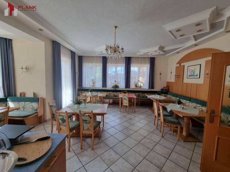 Heller Essbereich mit traditionellen Holzmöbeln, Fliesenboden und gemütlichen Sitzbänken.