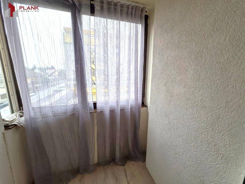 Helle Loggia mit großen Fenstern und leichten Vorhängen, bietet zusätzlichen Wohnraum.