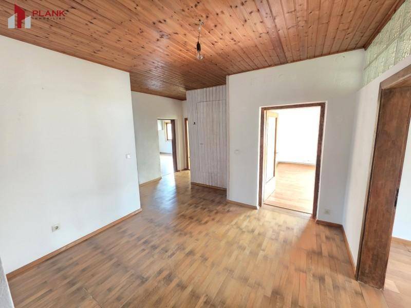Heller Flur mit Holzdeckenverkleidung und Holzboden, der verschiedene Wohnbereiche verbindet.