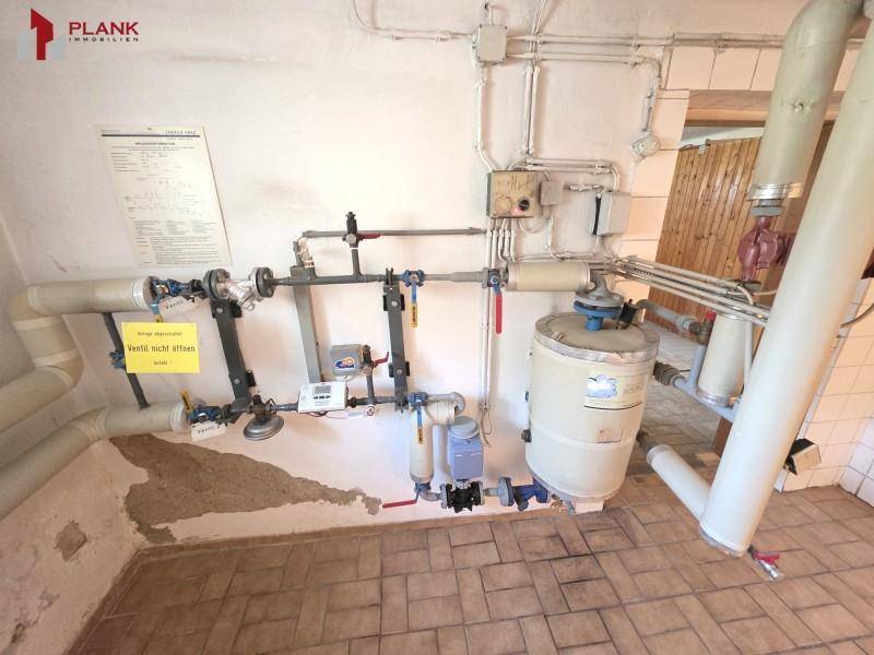 Technikraum mit Heizungsanlage und Rohrleitungen, essentiell für die Hausversorgung.
