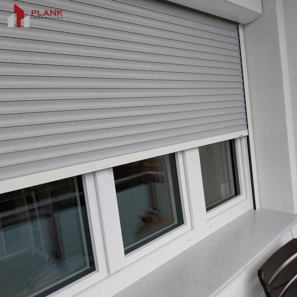 Fenster mit Außenjalousien, die für Privatsphäre und Sonnenschutz sorgen.