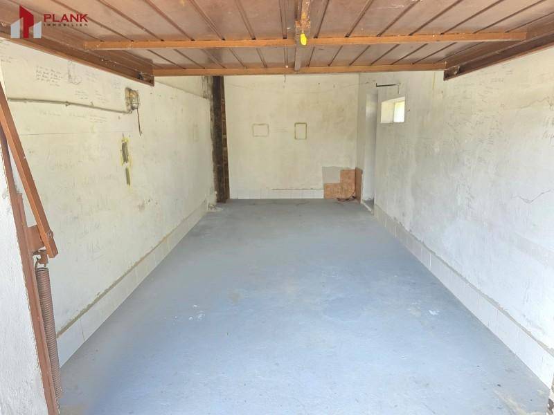 Geräumige Garage mit Betonboden und einfachen Wänden, bereit zur Nutzung.