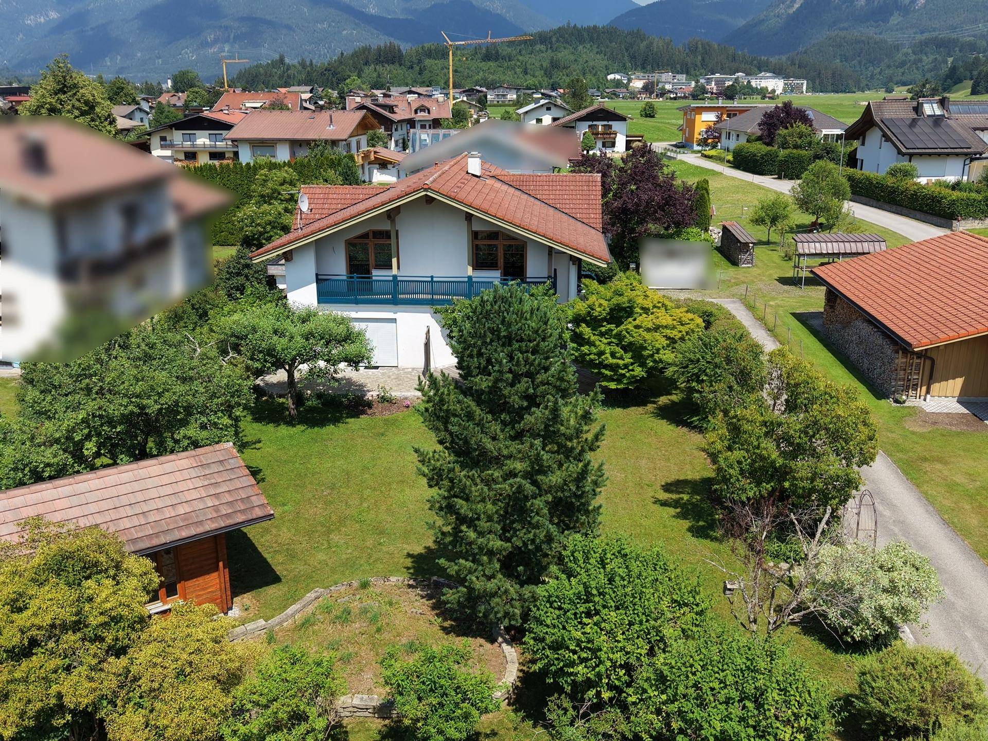 Luftaufnahme eines Einfamilienhauses mit großem Garten, umgeben von einer ländlichen Wohnsiedlung.