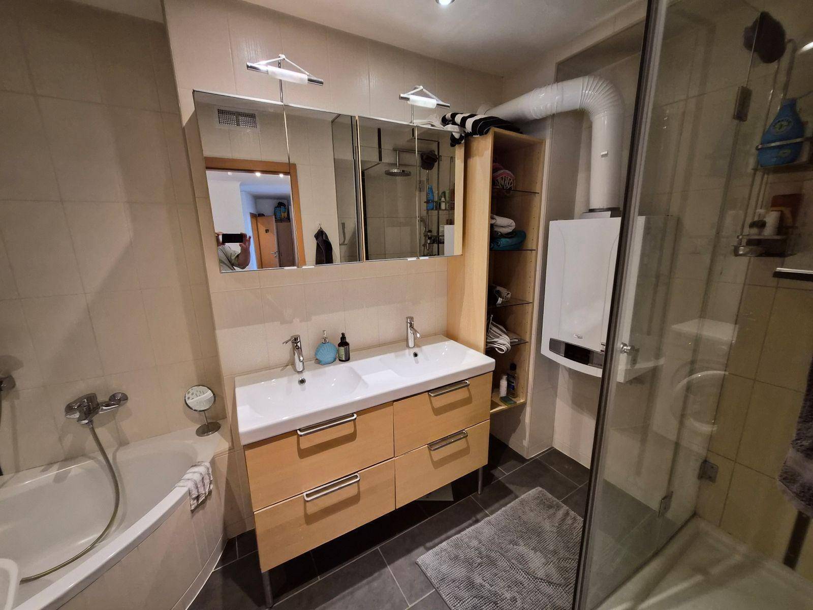 Geräumiges Badezimmer mit Doppelwaschbecken, Duschkabine und Badewanne.