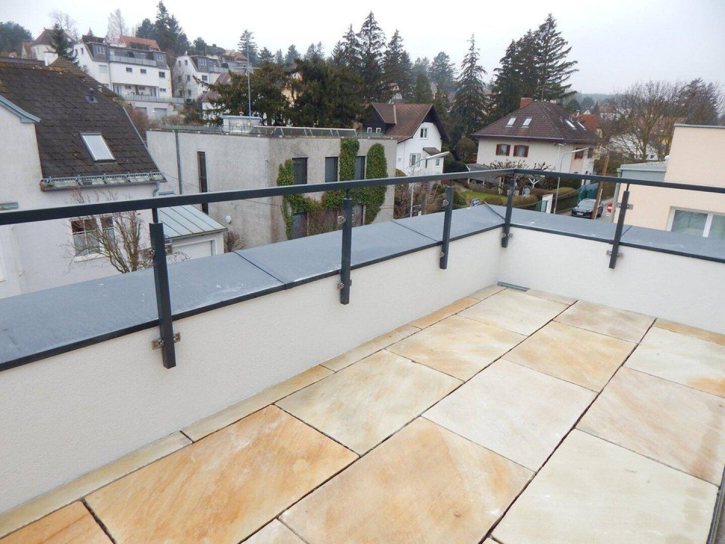 Geräumige Dachterrasse mit Fliesenboden und weitem Blick über die verschneite Umgebung.