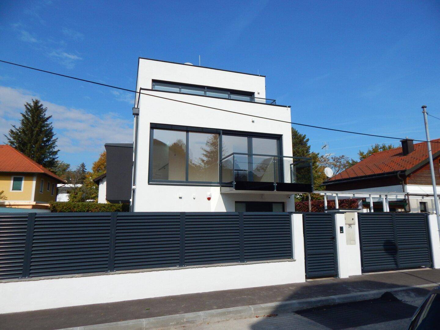 Die moderne Architektur des Hauses mit klaren Linien und großen Fensterfronten.