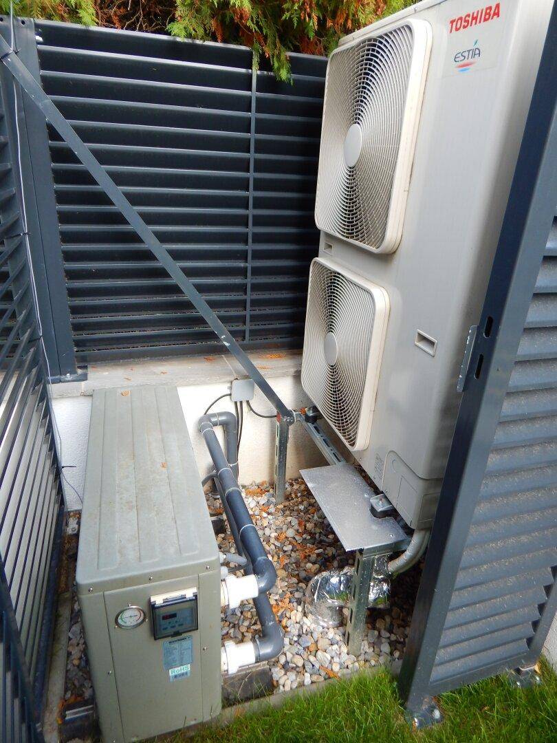 Außenansicht einer modernen Toshiba Wärmepumpe, umgeben von einem Schutzgitter.