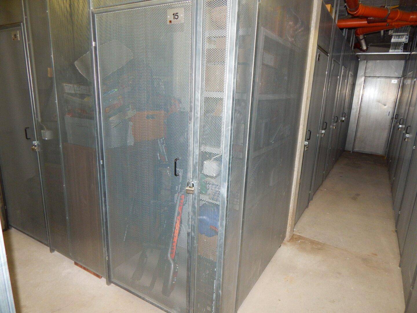 Reihe von abschließbaren Kellerabteilen aus Metallgitter für zusätzlichen Stauraum.