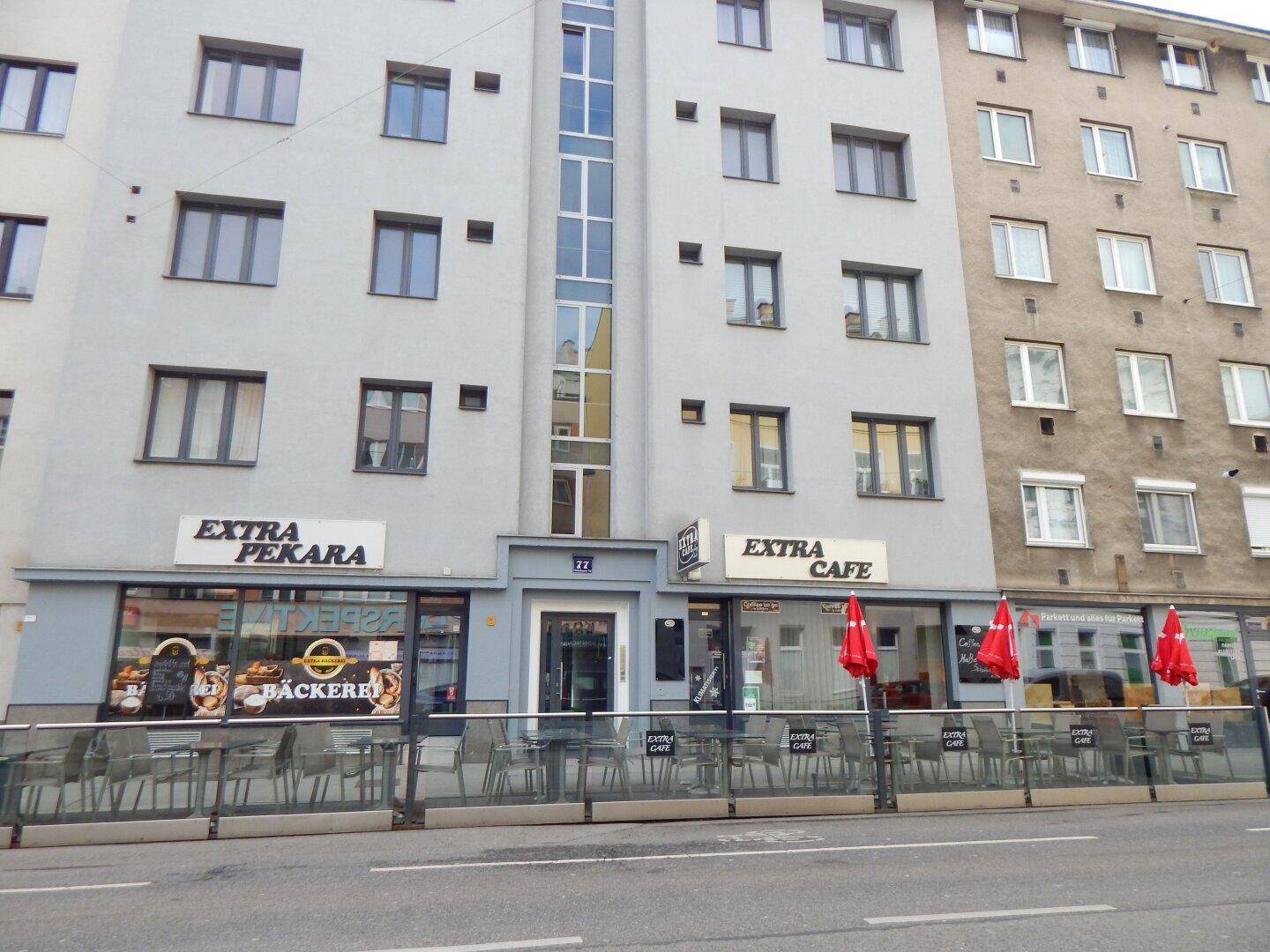 Fassade eines Gebäudes mit Bäckerei und Café im Erdgeschoss und Wohnungen darüber.