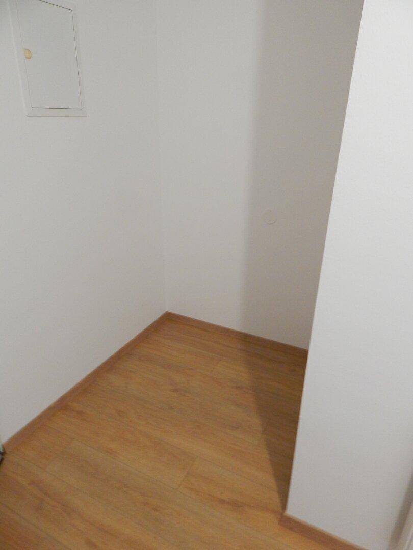 Kleiner Abstellraum mit Laminatboden und weißen Wänden, ideal für zusätzlichen Stauraum.