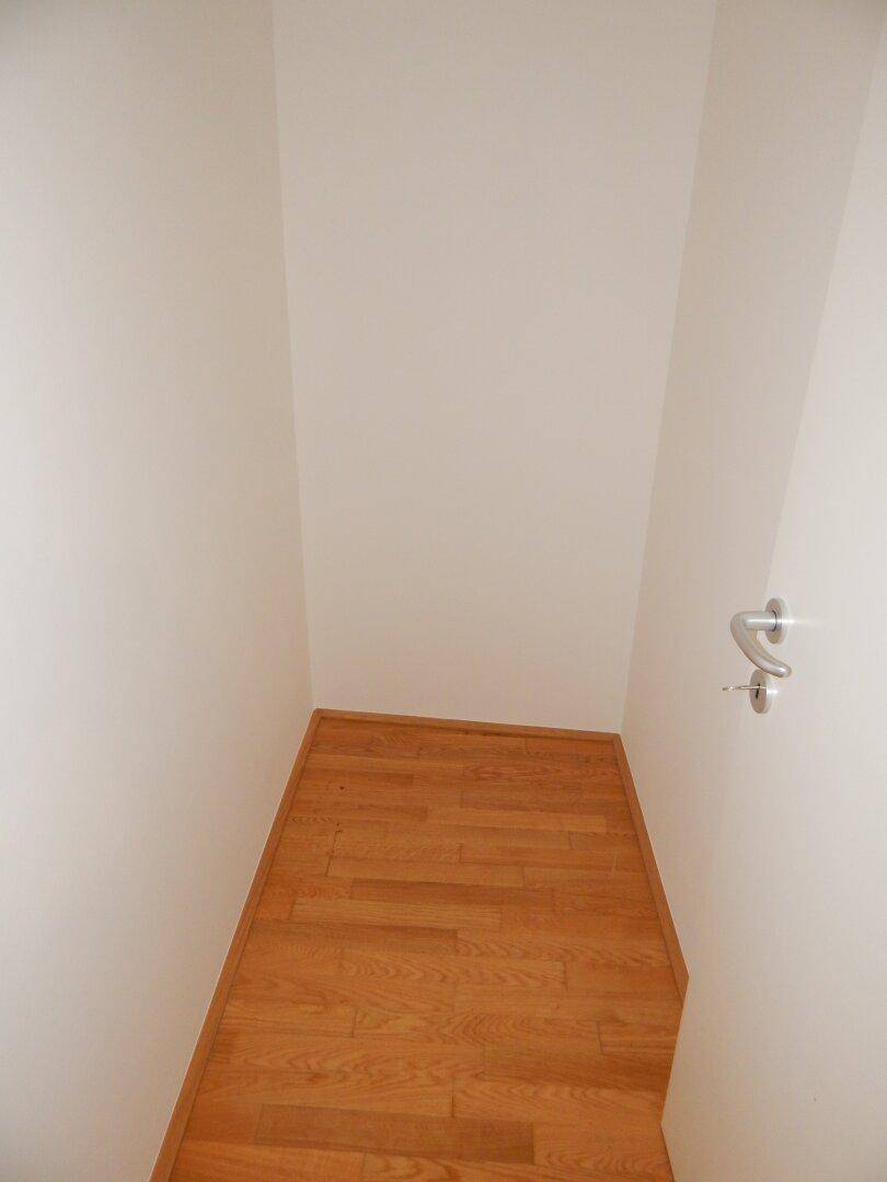 Kleiner Abstellraum mit Parkettboden und weißen Wänden, ideal für zusätzlichen Stauraum.