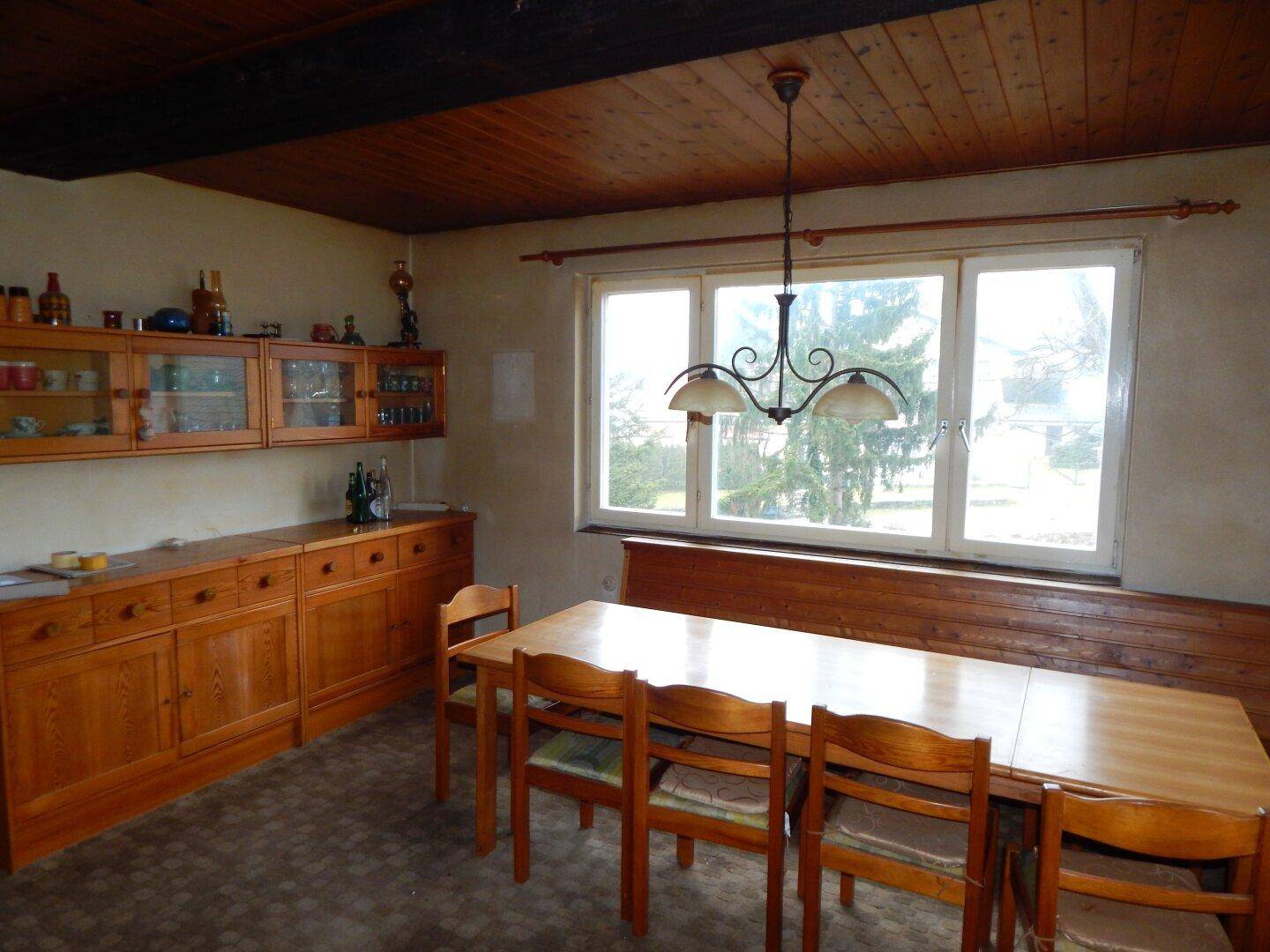 Gemütlicher Essbereich mit Holztisch, Eckbank und Holzdecke, ideal für Familienmahlzeiten.