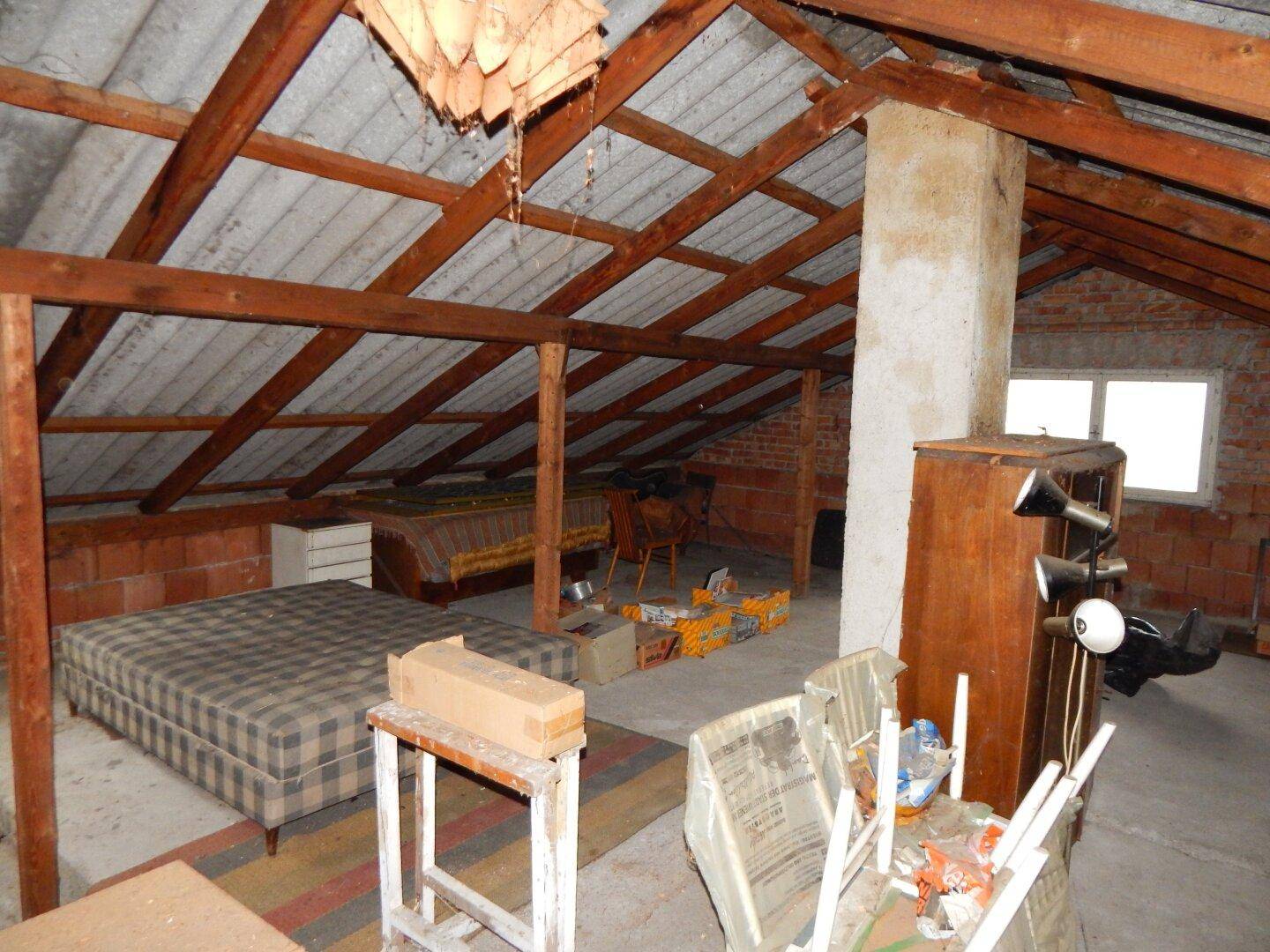 Geräumiger Dachboden mit sichtbaren Holzbalken und Fenstern, bietet Ausbaupotenzial.