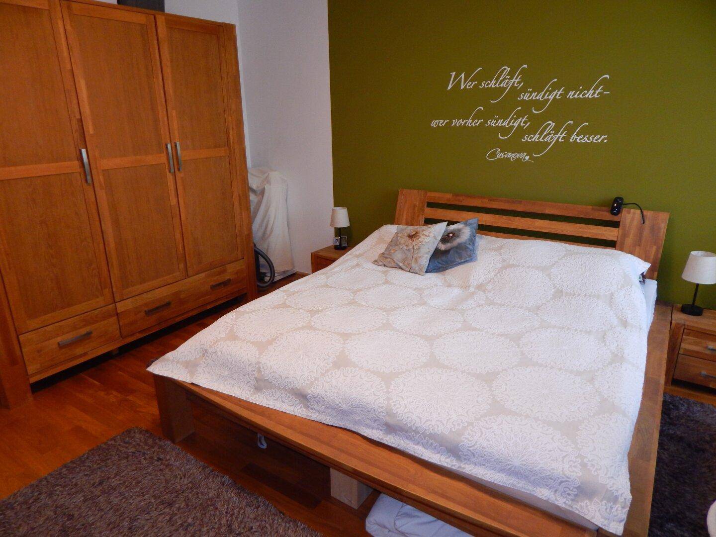 Geräumiges Schlafzimmer mit Holzbett, Kleiderschrank und Holzboden.