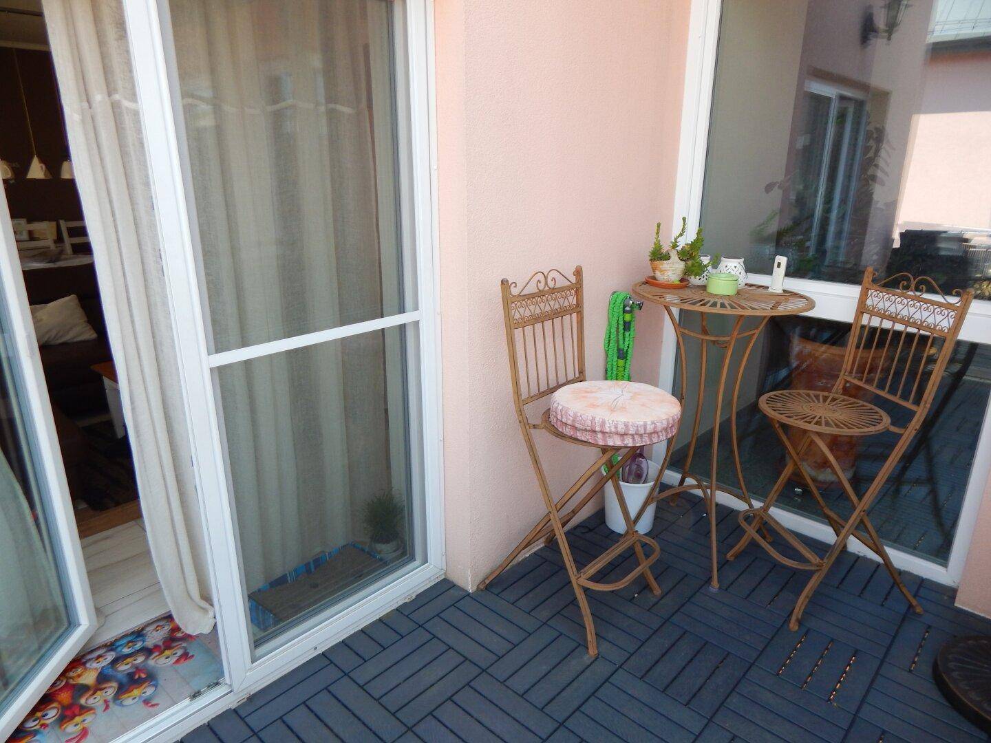 Kleiner Balkon mit Outdoor-Möbeln und Blick auf die Umgebung.