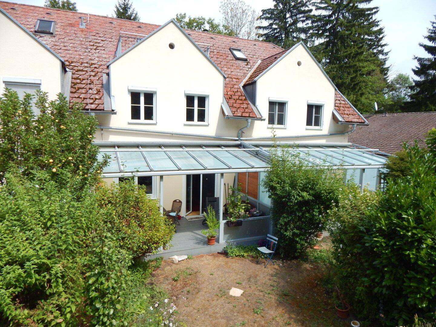 Vogelperspektive des Hauses mit Wintergarten und dem dahinterliegenden Gartenbereich.