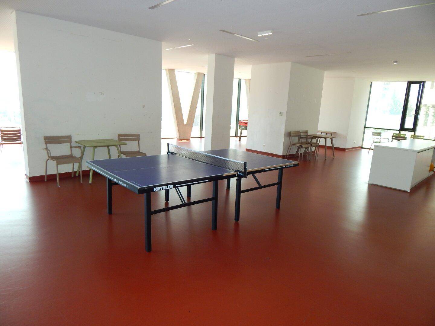 Großer Gemeinschaftsraum mit Tischtennisplatte und Sitzgelegenheiten.