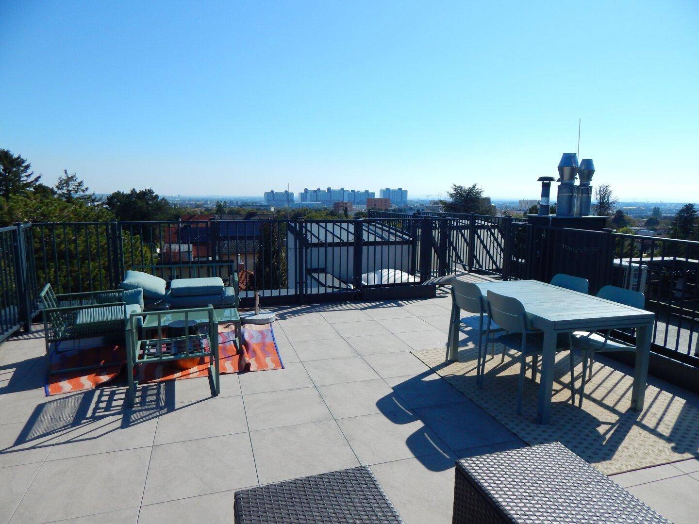 Weitläufige Dachterrasse mit Sitzgelegenheiten und beeindruckendem Panoramablick auf die Umgebung.