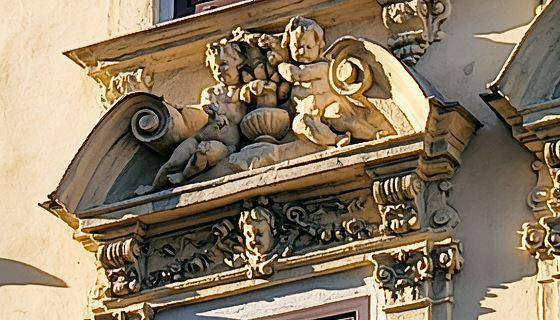 Detailaufnahme von kunstvollen Stuckverzierungen und Skulpturen an der historischen Gebäudefassade.