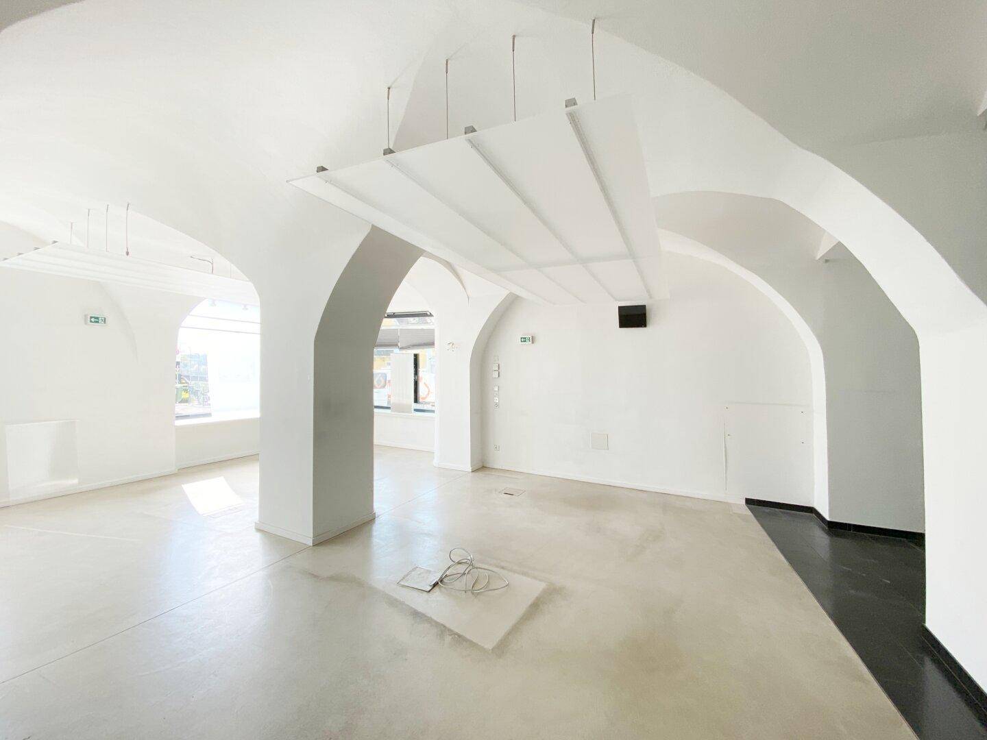 Weitläufiger Gewerberaum mit markanten Gewölbedecken und tragenden Säulen, die eine offene Atmosphäre schaffen.