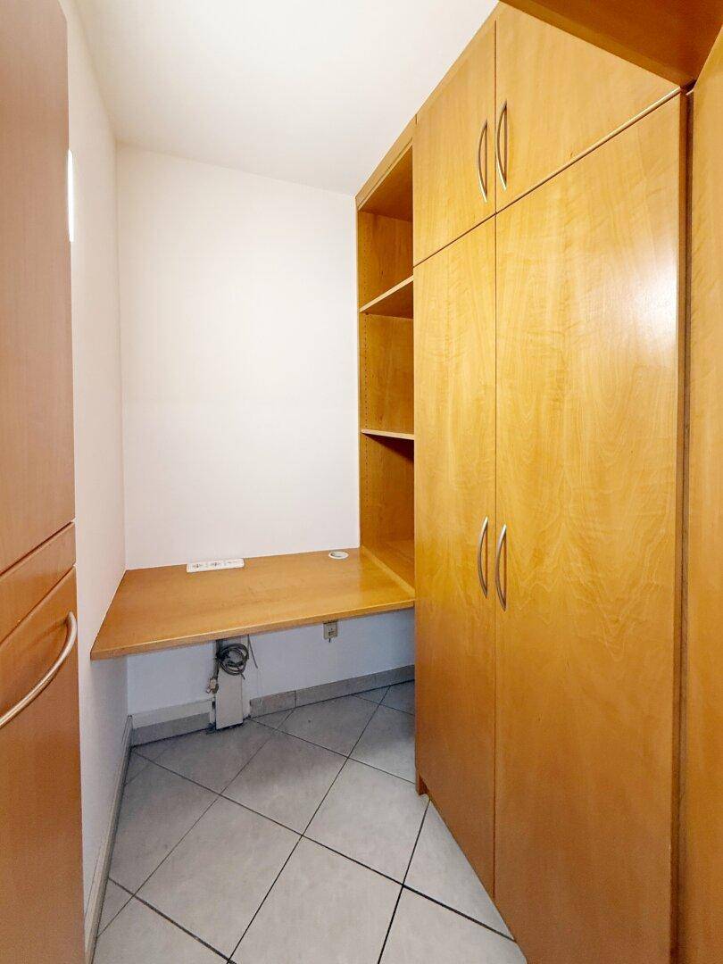 Kleiner Arbeitsbereich mit integriertem Holzschreibtisch und passenden Holzschränken, ideal für konzentriertes Arbeiten.