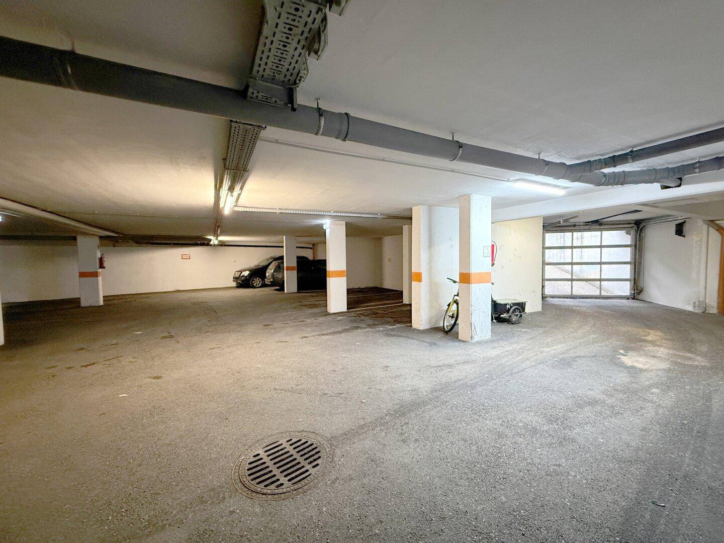 Geräumige Tiefgarage mit mehreren Stellplätzen und einfacher Beleuchtung.