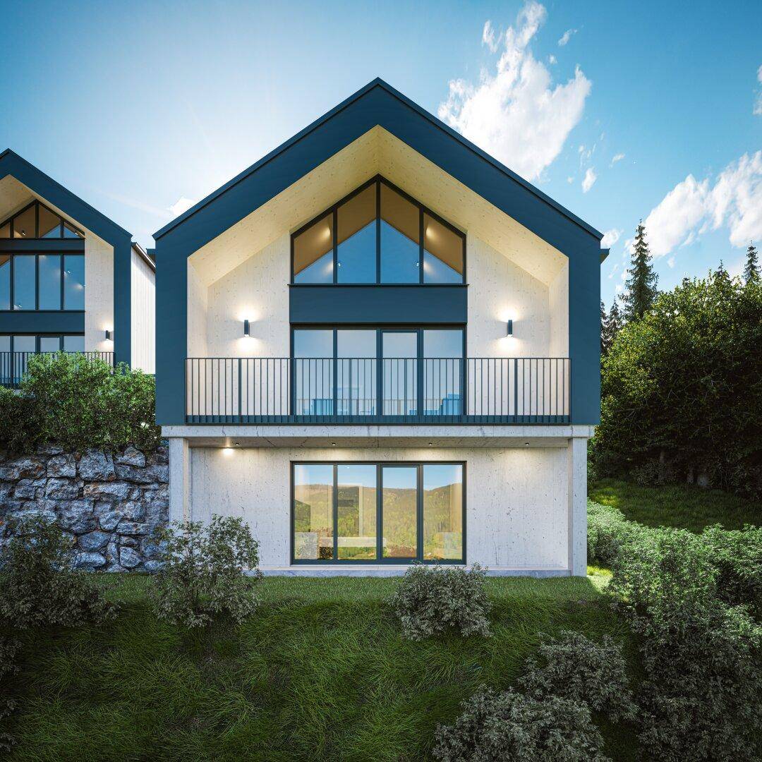 Frontansicht eines modernen Chalets mit Balkon und großen Giebelfenstern vor Bergkulisse.