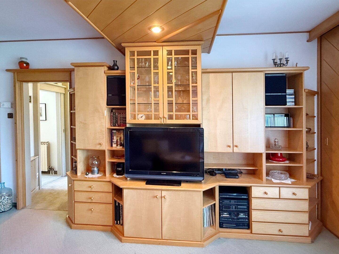 Detaillierte Ansicht der Holz-Wohnwand mit Fernseher und vielen Ablagemöglichkeiten.