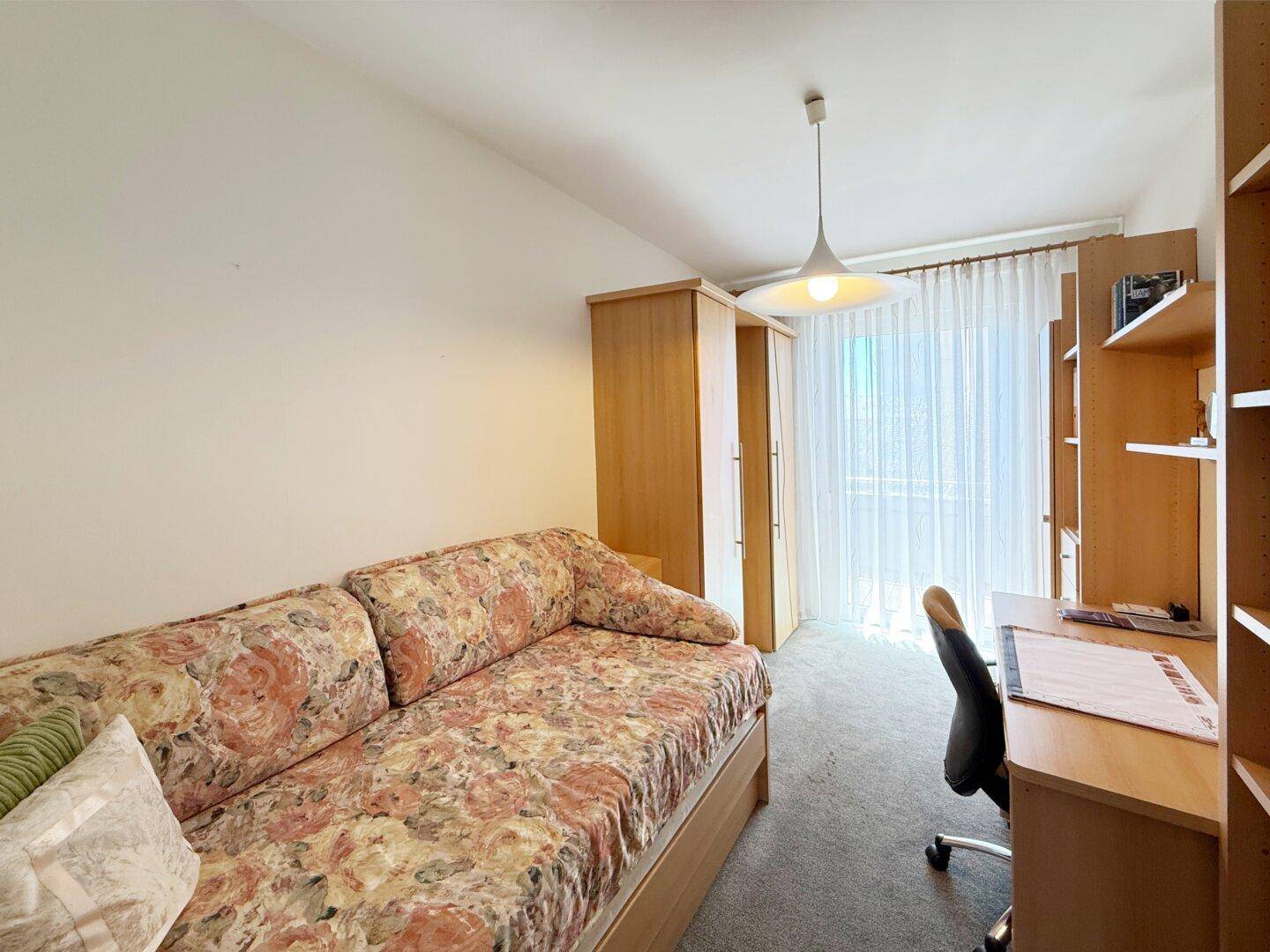 Helles Zimmer mit Tagesbett, Schreibtisch und Kleiderschrank, ideal als Gäste- oder Arbeitszimmer.