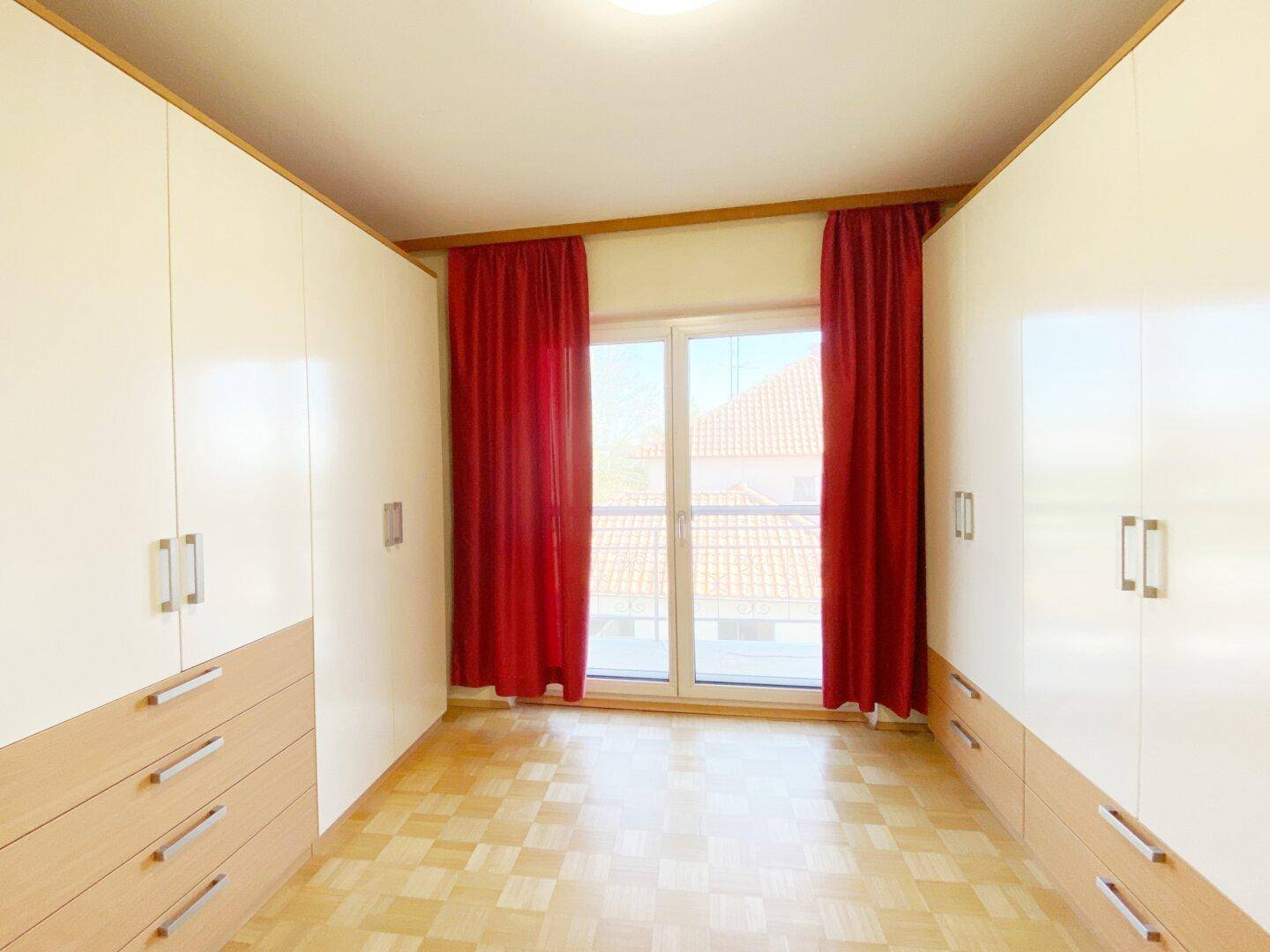 Raum mit Parkettboden und beidseitigen Einbauschränken, ideal als Ankleidezimmer oder Schlafzimmer.