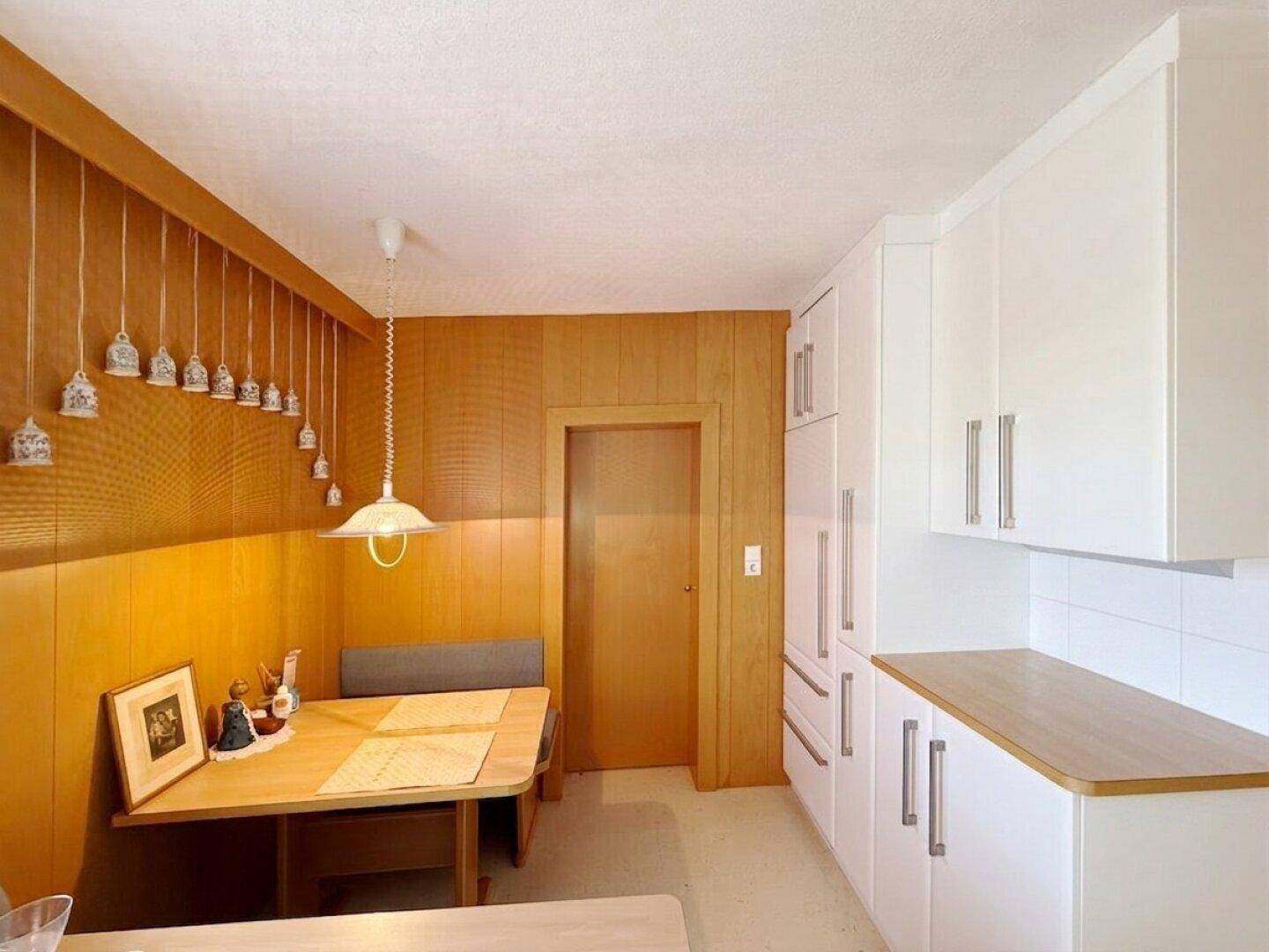 Gemütliche Essecke in der Küche mit Holzvertäfelung und traditioneller Einrichtung.