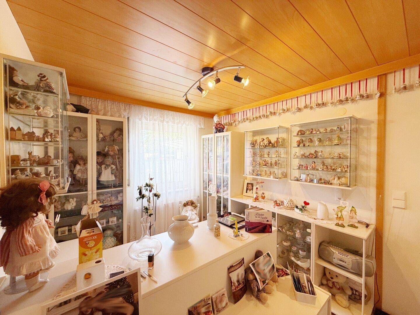 Zimmer mit zahlreichen Vitrinen und Sammlerstücken, ideal als Hobbyraum.